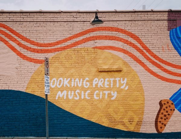pink and yellow mural in nashville that says looking pretty music city