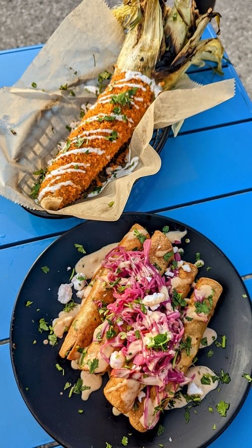 vegan taquitos and elotes on a blue table at rad.ish street food in traverse city