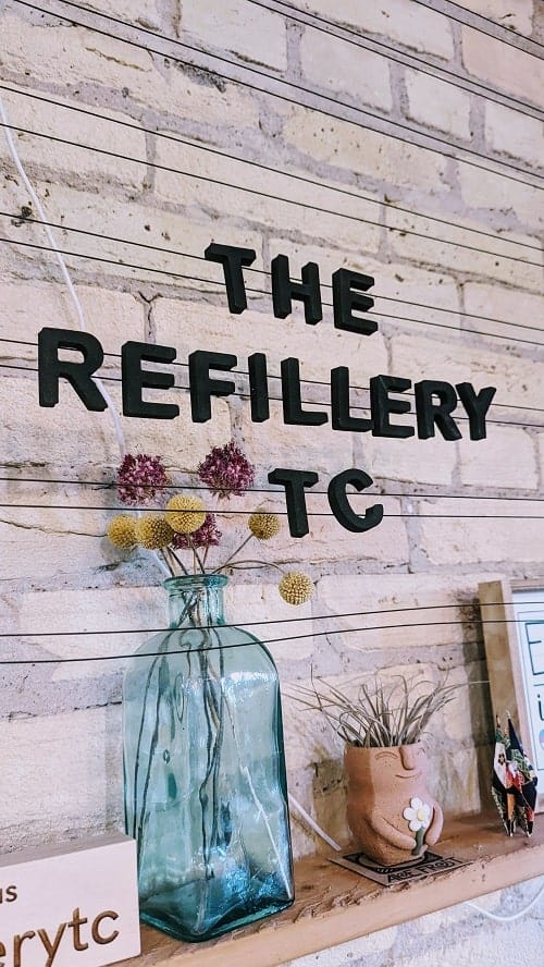 the refillery lettered sign on a wall in the village commons in traverse city