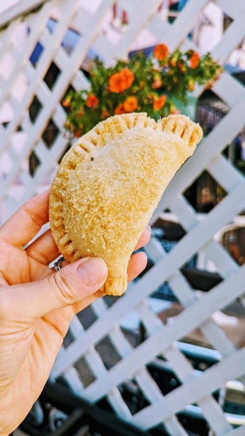 vegan and gluten free apple turnover in front of a white lattice fence with flower in dc