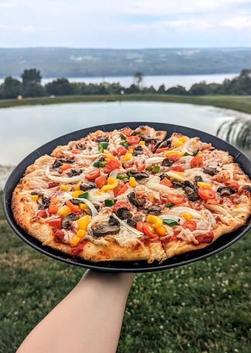 vegan veggie pizza from grist iron brewing with the finger lakes in the background

