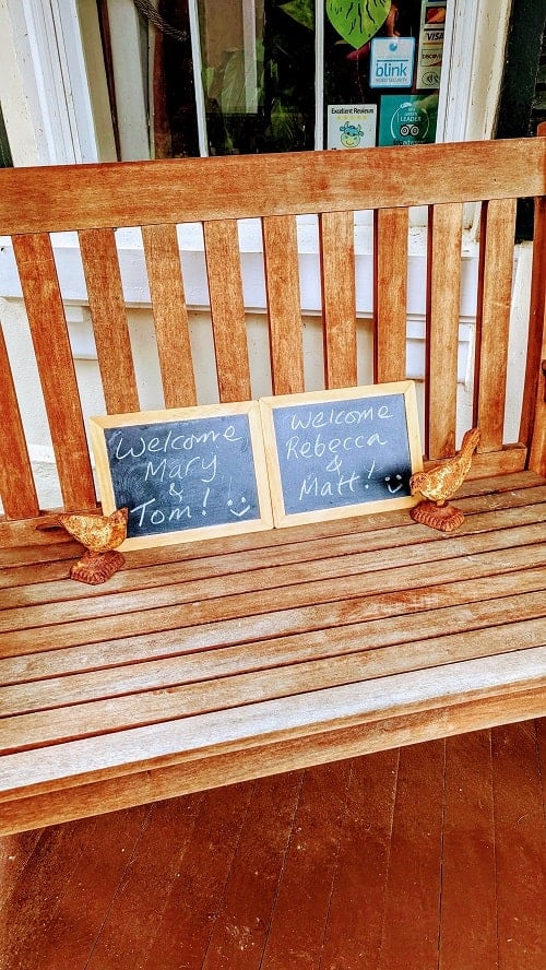 chalk board welcome signs for guests sitting on a bench outside the entrance for black sheep inn and spa in the finger lakes
