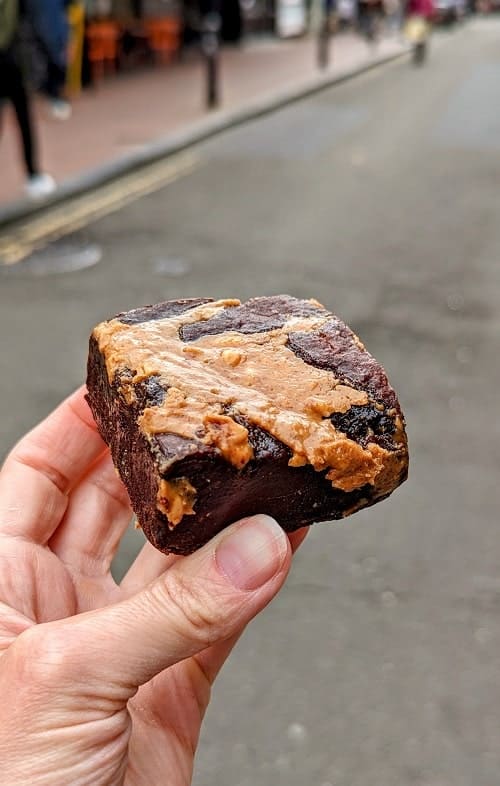 vegan gluten free peanut butter brownie held on a street in brighton