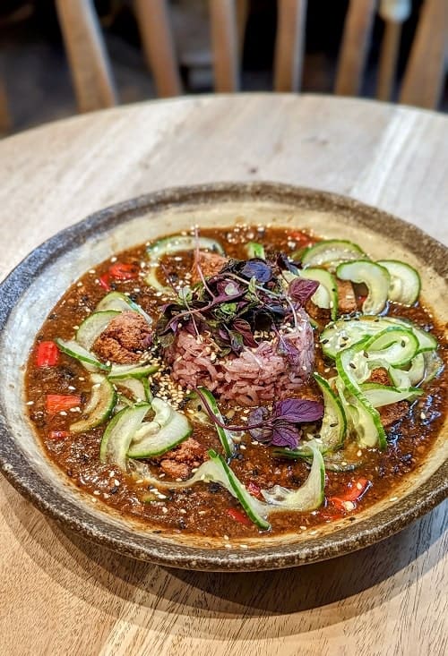 bowl of vegan mapo tofu with spiralized cucumber on top at food for friends in brighton