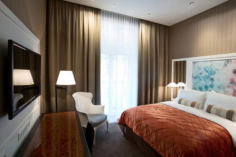 inside of a modern guest room with dark linen and the drapes pulled at the vegan-friendly harmonie hotel in vienna