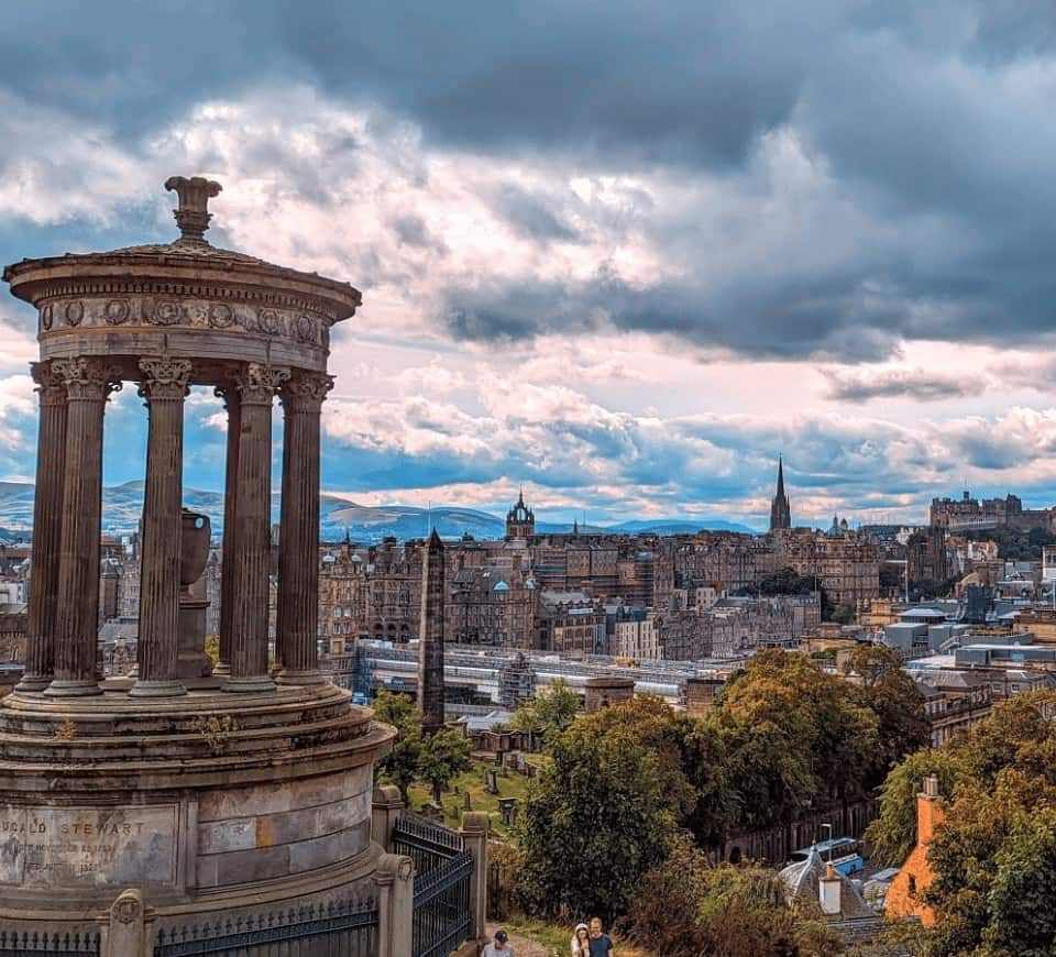 view of edinburgh old town from calton hill on a cloudy, gloomy day with a darkening of the clouds