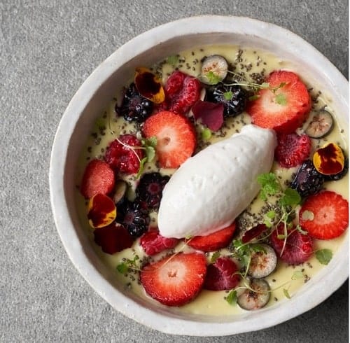 a small white fruit bowl topped with vegan coconut yogurt in london