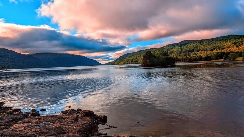sunrise at loch lomond with a light blue and pink sky