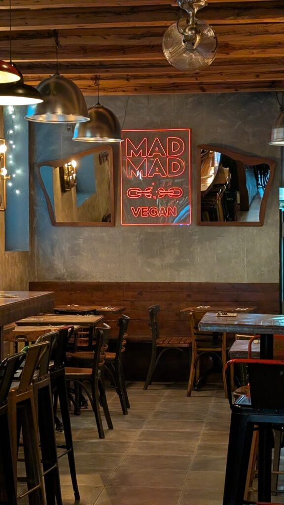 neon red mad mad vegan sign in the dining room of the vegan restaurant 