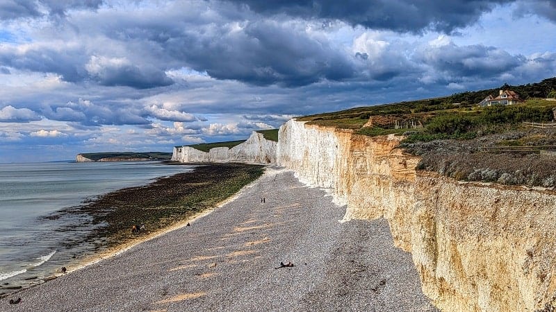 view of the seven sisters giant white chalk cliffs from the gray stone beach at the birling gap