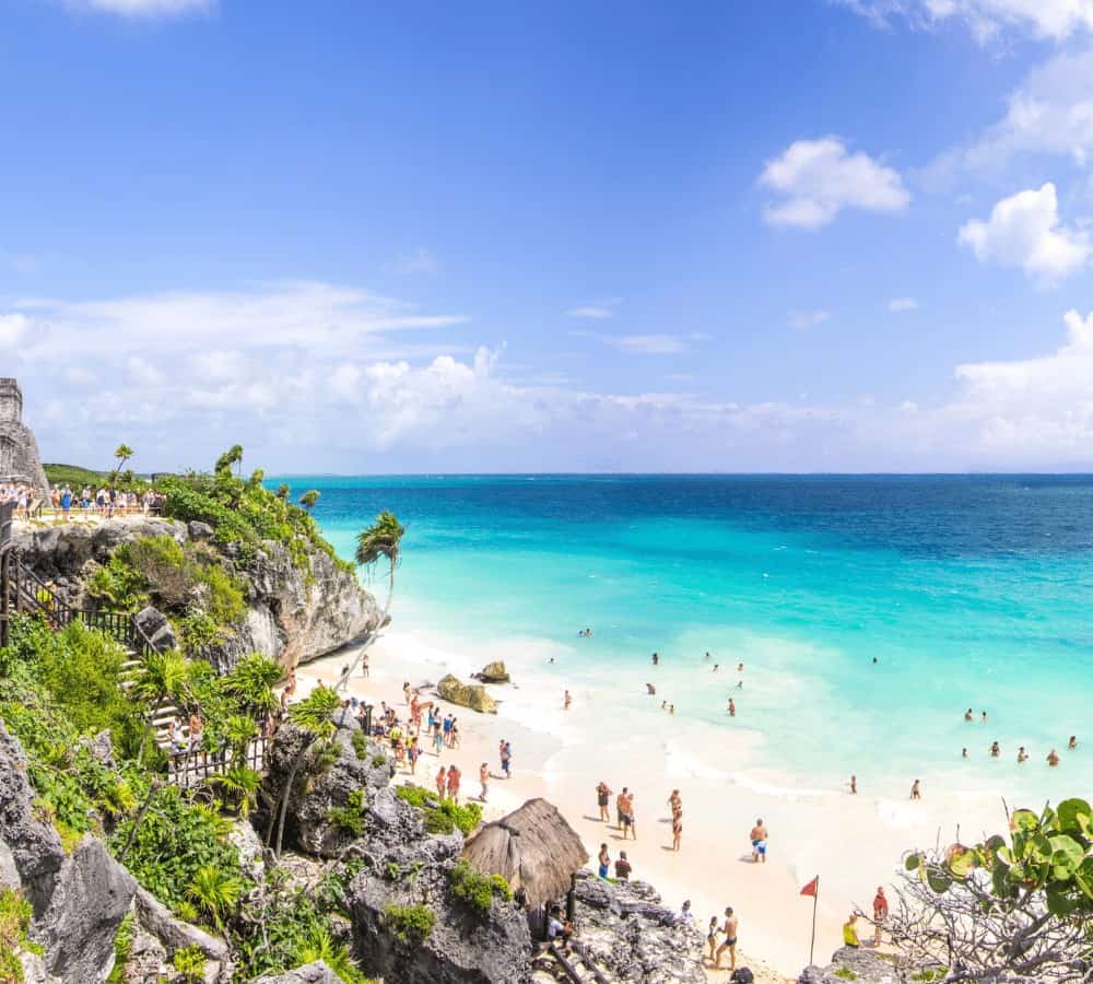 white sand beach with bright turquoise water on a sunny day in mexico
