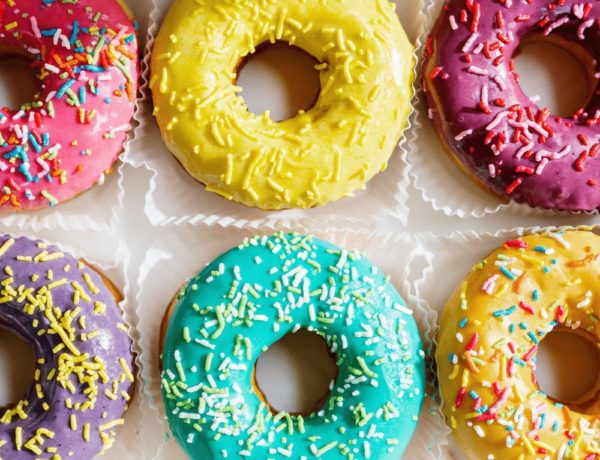 bright green, yellow, and pink cake donuts topped with colorful sprinkles