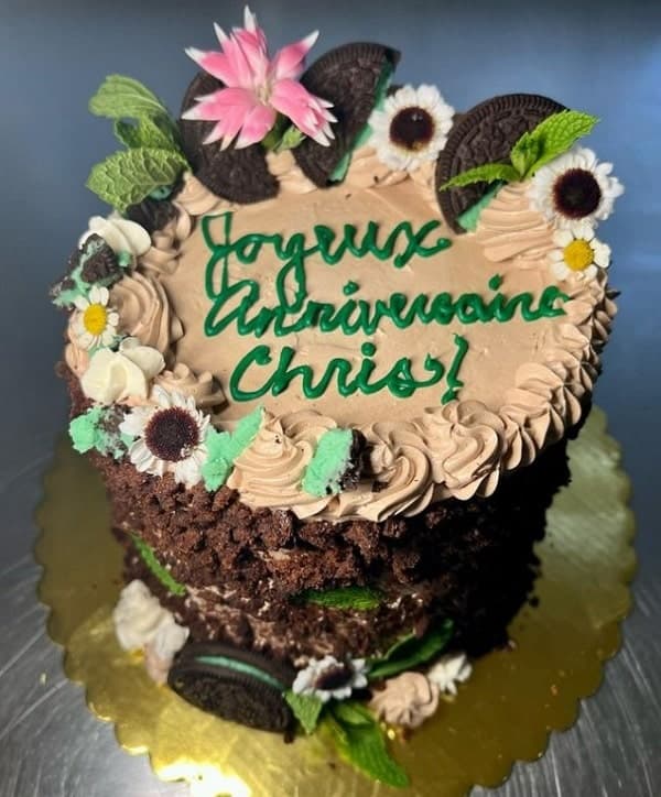 a small round vegan chocolate birthday cake with cookie crumbs on the side and topped with cookies and flowers from LH bakeshop in san francisco  