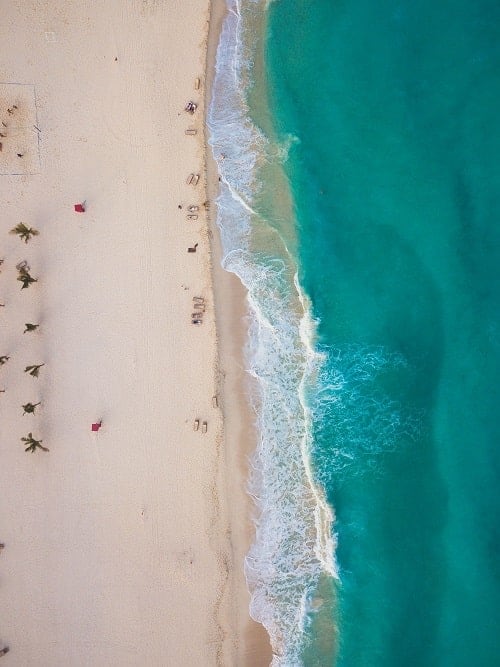 overhead view of white sand beach and blue water in mexico