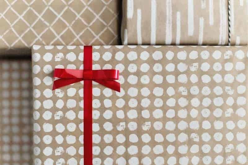 multiple wrapped gifts with white polka dots and a red bow