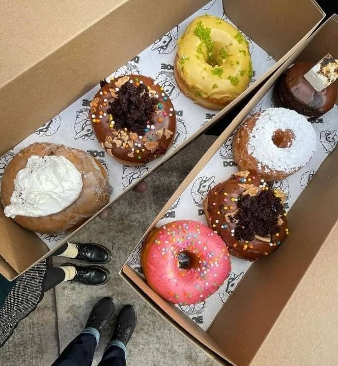 two bown rectangle boxes filled with colorful vegan donuts in portland