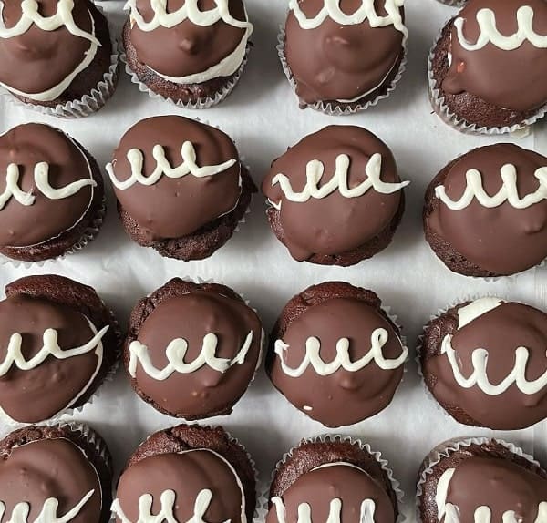 overhead shot of four lines of vegan chocolate cupcakes topped with little white icing swirls at cake girl in LA