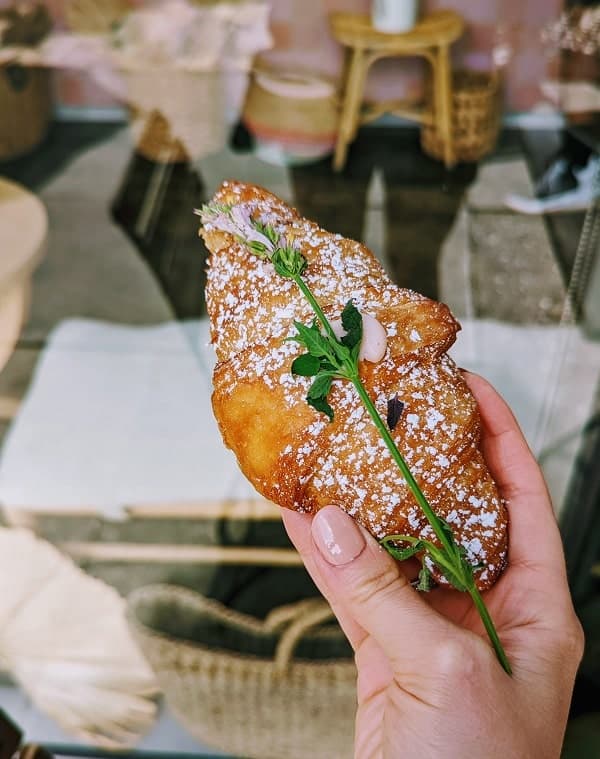 golden vegan croissant topped with powdered sugar and a green spring at chaumont vegan in LA