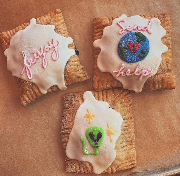 three vegan pop tarts topped with light-colored icing, a picture of earth, an alien, and one says fri-yay at just what i kneaded in LA