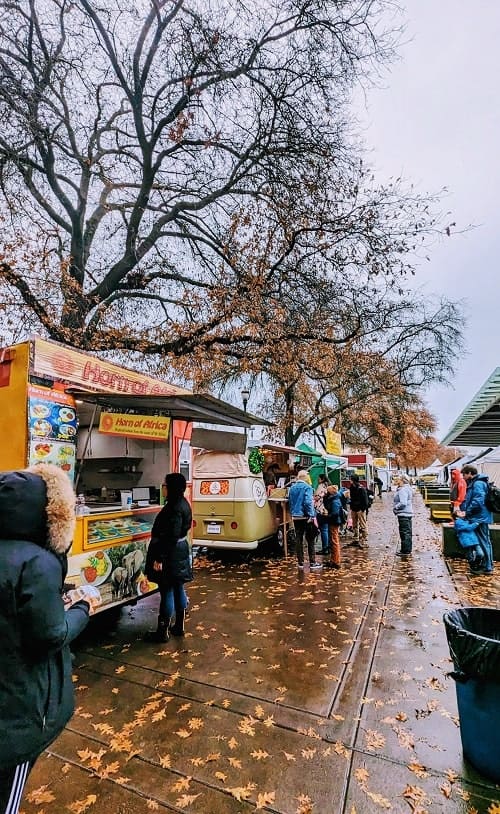 a rain day in december at portlands saturday market with a lineup of food trucks