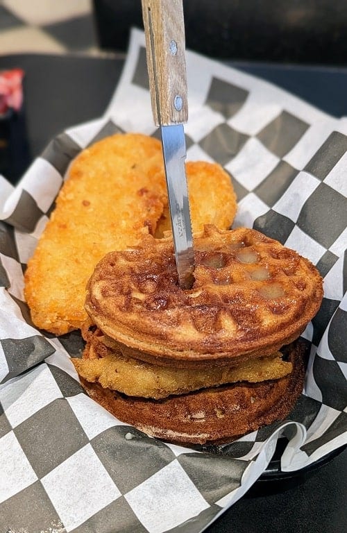 vegan waffle breakfast sandwich with fried chicken and two golden hashbrowns at ro's diner in NYC