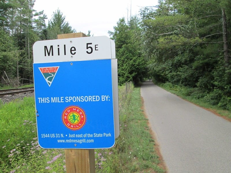 directional sign up close next to the paved traverse area recreation trail