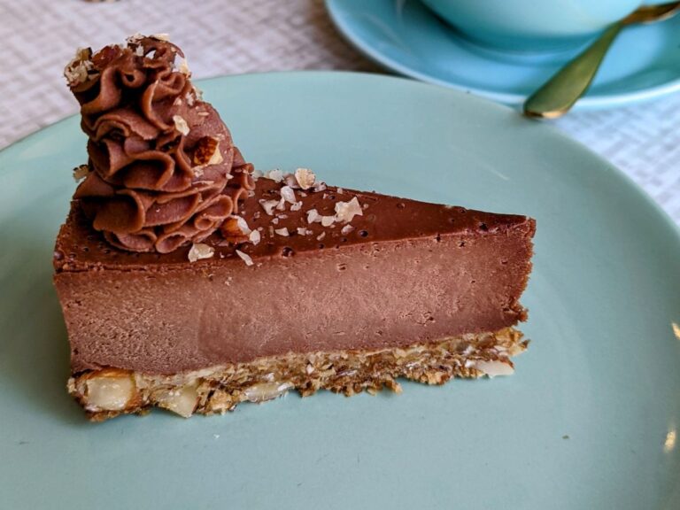 a slice of vegan chocolate cheesecake on a light blue plate in london