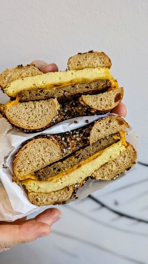 a vegan everything bagel sandwich cut in half and filled with sausage and egg at ben and esthers in seattle