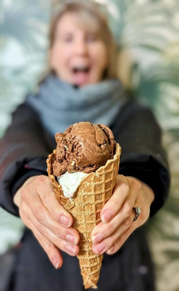 rebecca gade sawicki holding a vegan waffle cone filled with a scoop of chocolate and a scoop of peanut butter ice cream at frankie and jos in seattle