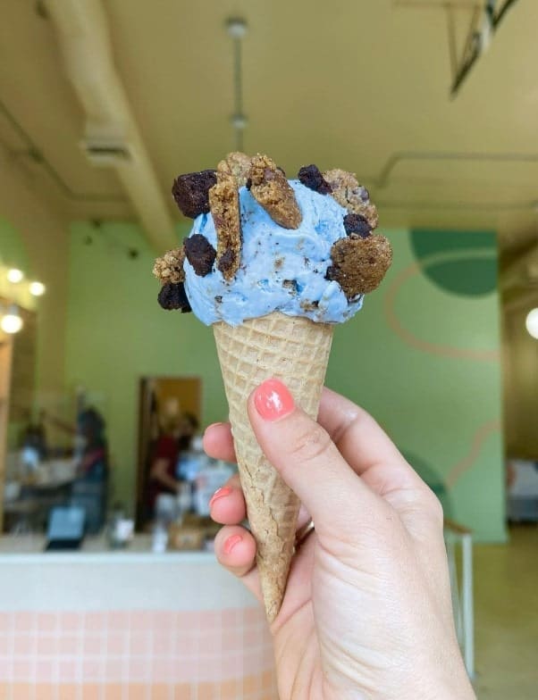 vegan and gluten free waffle cone filled with a scoop of blue ice cream covered in cookie pieces in portland