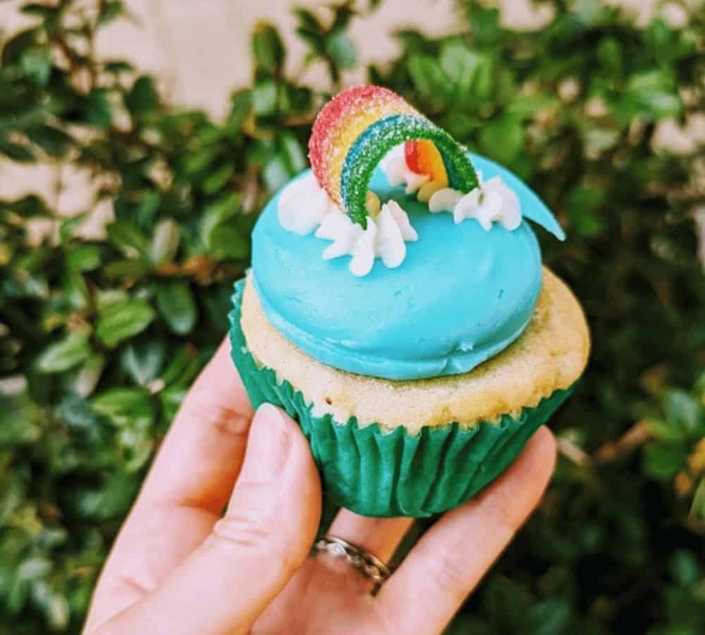 vegan vanilla cupcake topped with blue butter cream and a candy rainbow from sticky fingers in washington dc