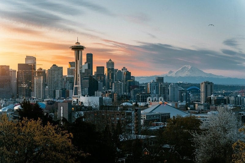 the seattle skyline take from kerry park at sunset with hues of pink and orange in the sky