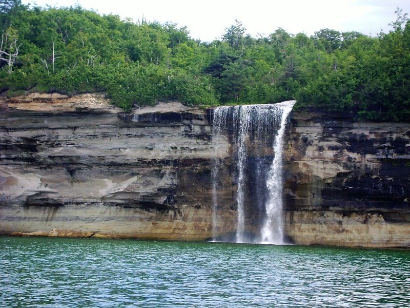 spray falls waterfall plunging into lake superior off of pictured rocks national lakeshore in michigan