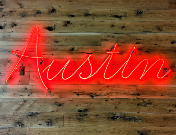austin red neon sign on a wood wall