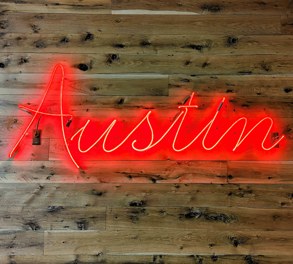austin red neon sign on a wood wall