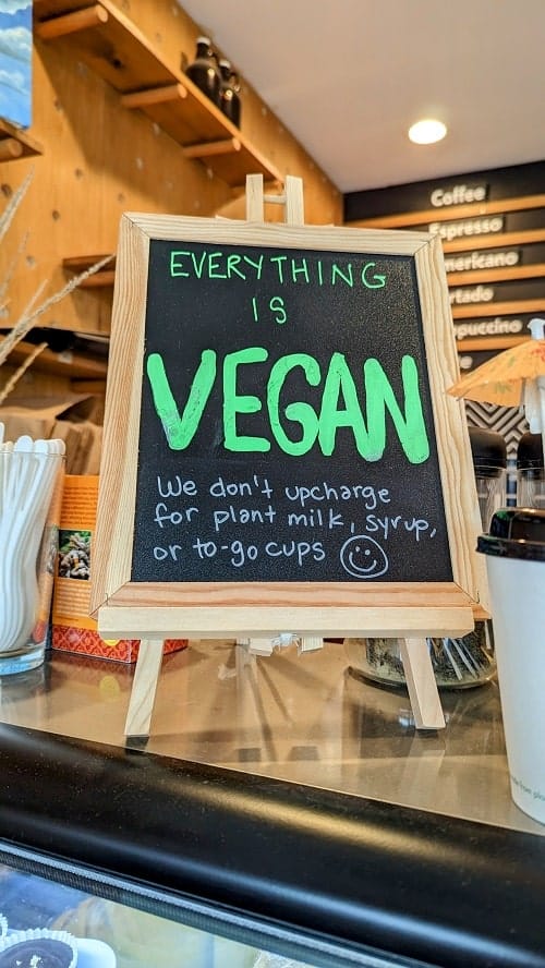 small chalkboard sign with green writing that says everything is vegan
