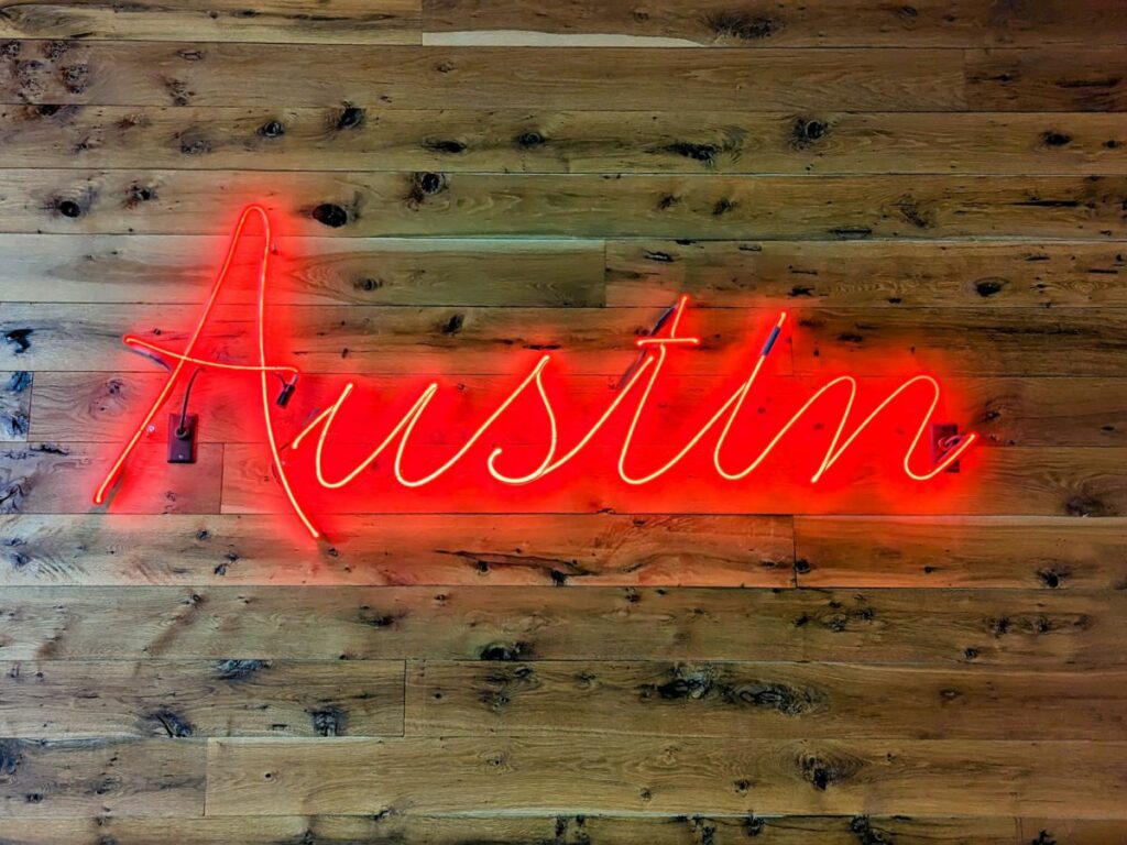 austin red neon sign on a wood wall