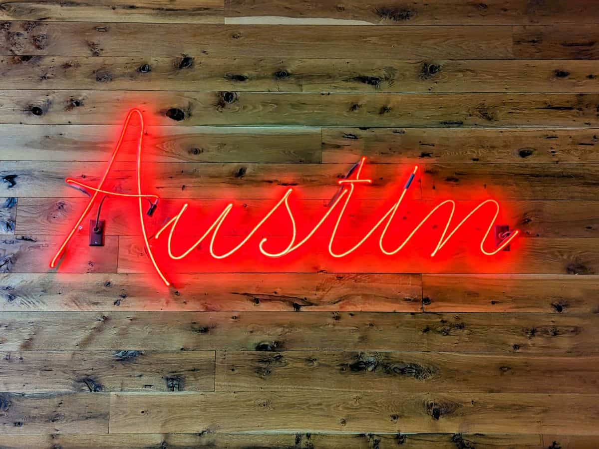 austin red neon sign on a wood wall