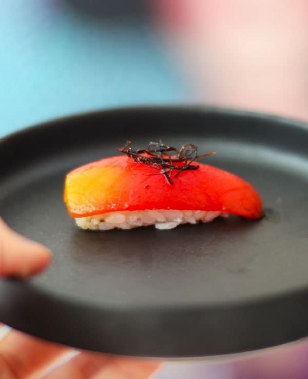 black round plate with one piece of vegan salmon nigiri sushi at omakaseed in NYC