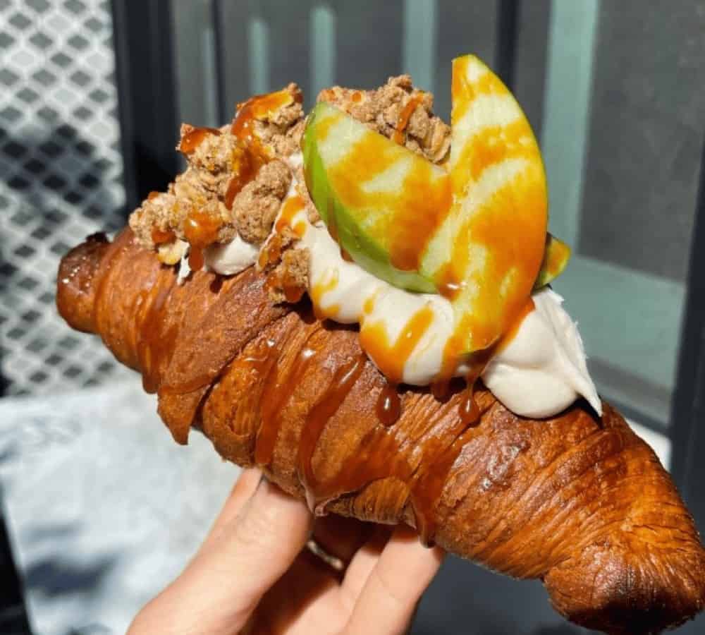 golden vegan croissant topped with cream and caramel apples from terms of endearment in NYC