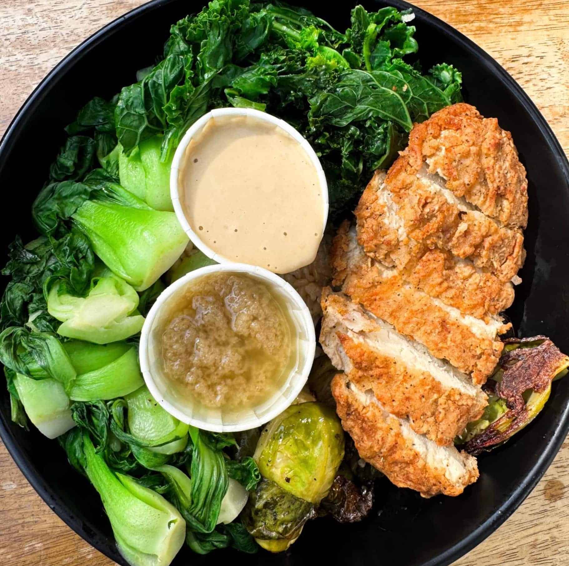 Vegan Peace Bowl from Peacefood with brown rice, baby bok choy, Brussels sprouts, kale, and a plant-based cutlet.