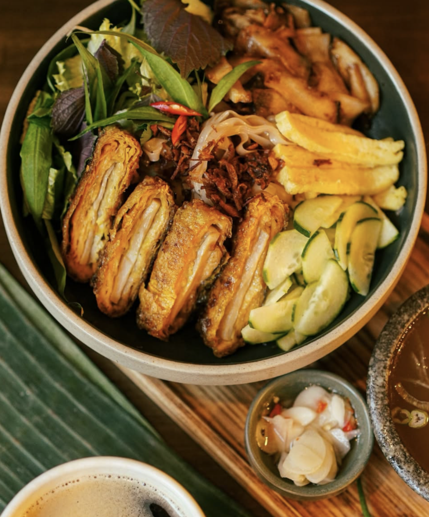 Vegan Vietnamese bowl at Viet Family Vancouver featuring crispy rolls, noodles, fresh vegetables, and pickled sides.