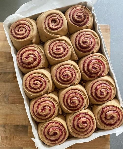 a tray of vegan sticky rolls freshly made on a wood table at ed's bred in whistler