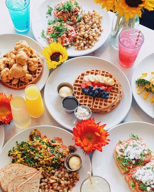 vegan brunch spread with waffles, tofu scramble, toast, and colorful drinks at kale my name in chicago