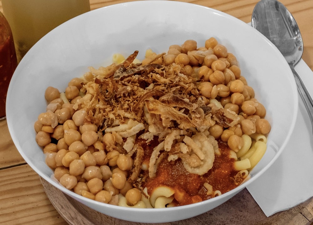 oshari Bowl, a layered mix of rice, lentils, macaroni, chickpeas, tangy sauce, and crispy fried onions
