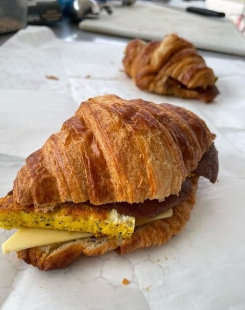 two vegan croissant sandwiches with egg and cheese at liberation kitchen in chicago