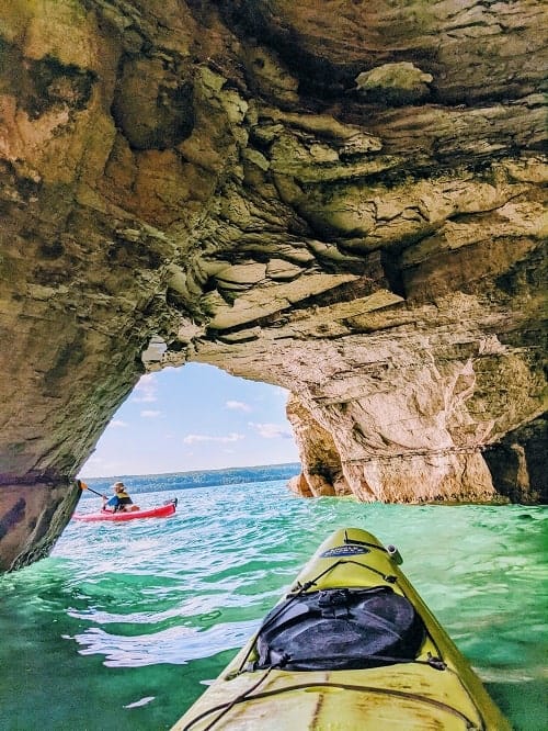 kayaking through a cliff cave in the pictured rocks national lakeshore