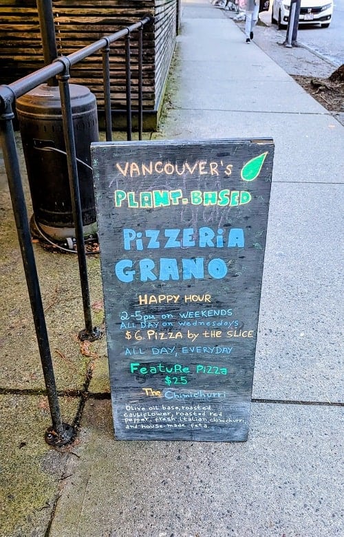black chalkboard welcome sign to the vegan pizzeria grano in vancouver