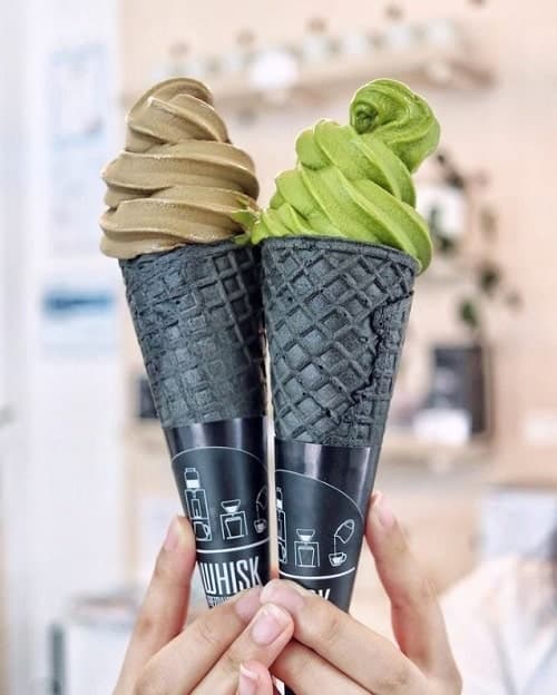 two black charcoal ice cream cones filled with green matcha ice cream and chocolate from softie vegan ice cream in vancouver