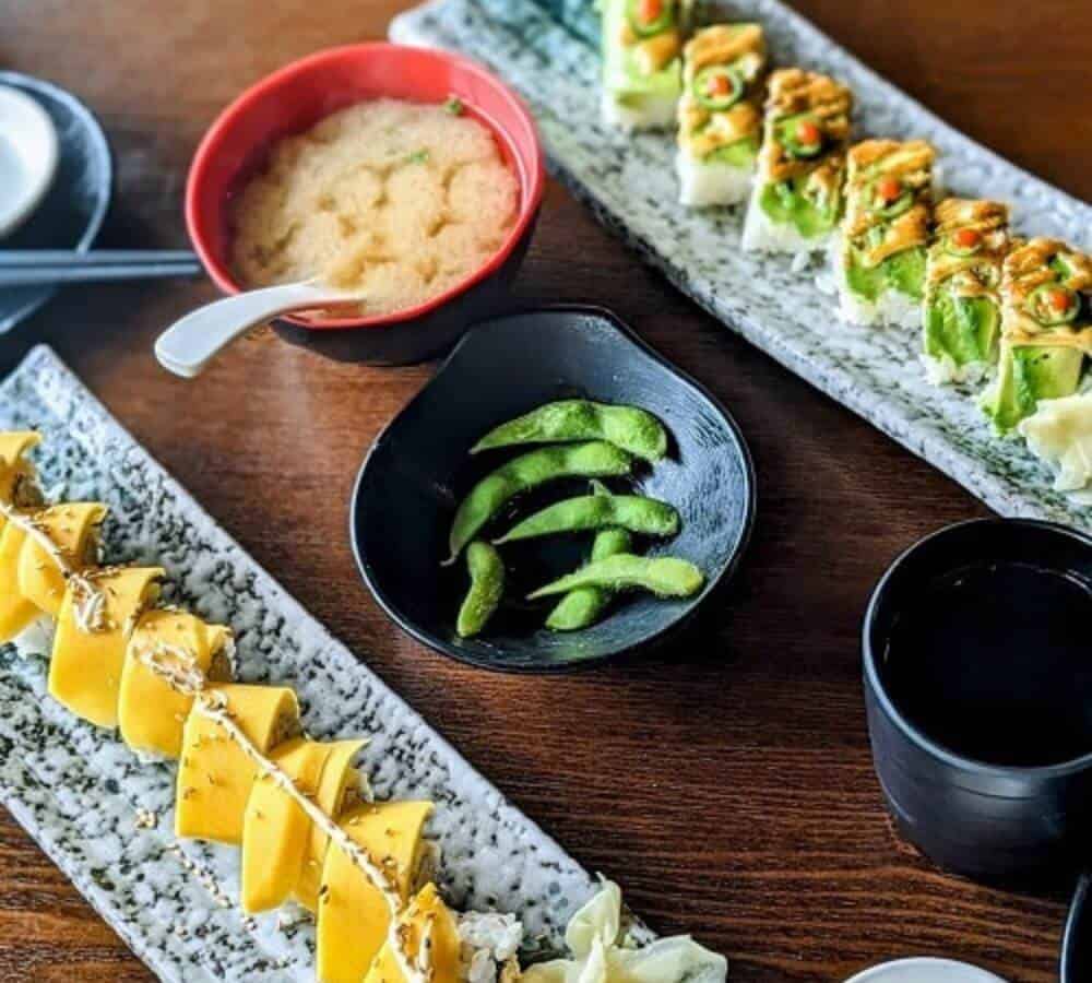 two sushi platters topped with avocado and mango with edamame and miso soup in vancouver